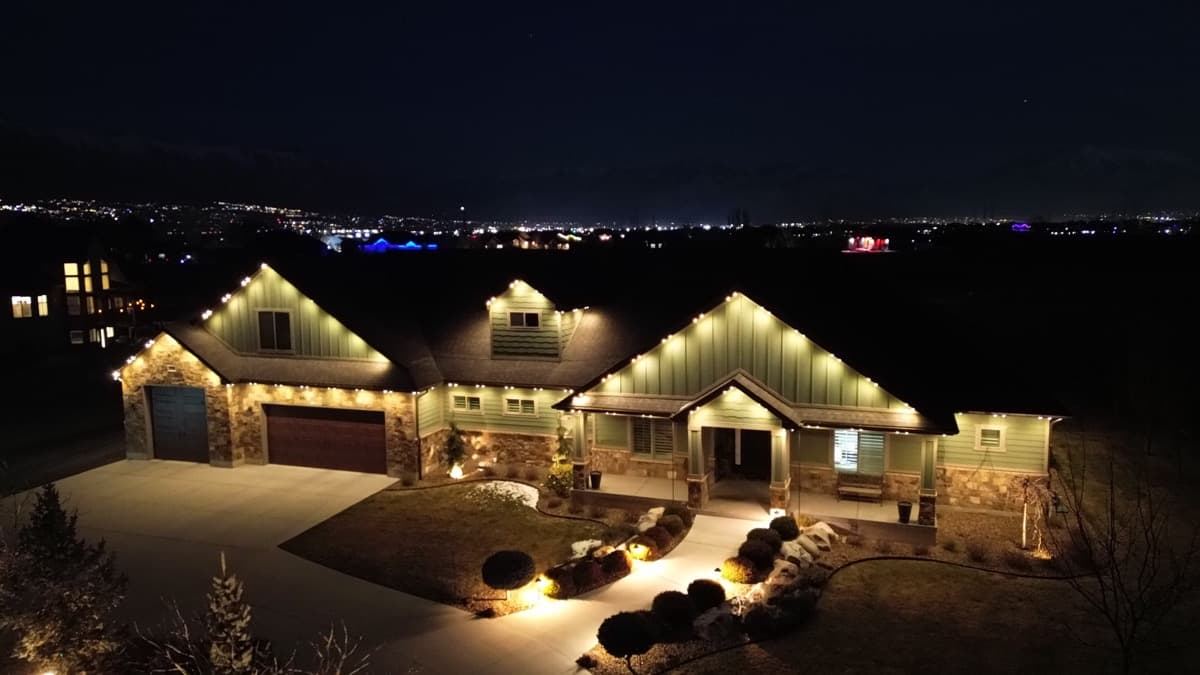 Salt Lake City ranch home fully lit by TruLight permanent LED with Wasatch Front city lights in the distance