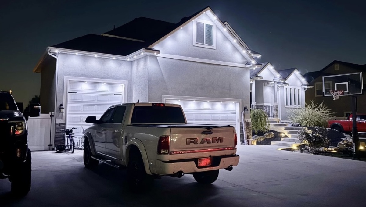 Permanent warm white LED roofline lighting on a Salt Lake City stucco home at night