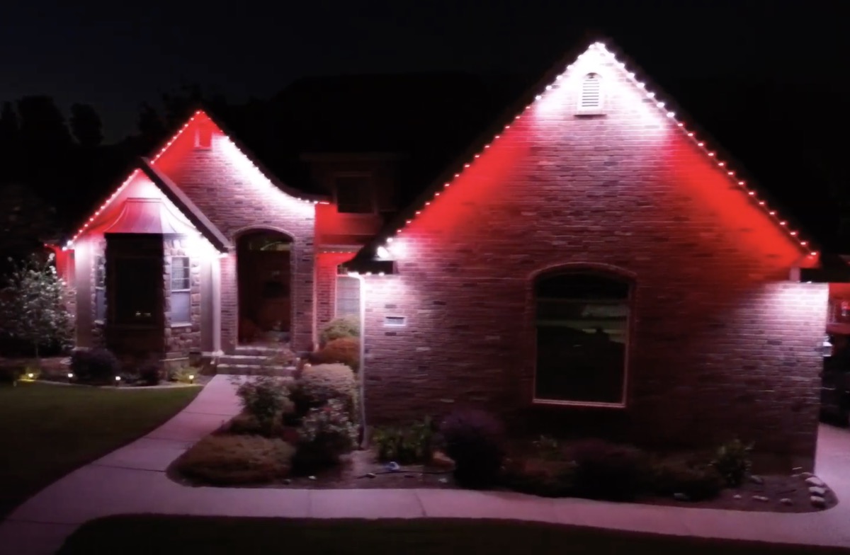 TruLight permanent lights showing red and white candy cane holiday colors on a Utah stone ranch home