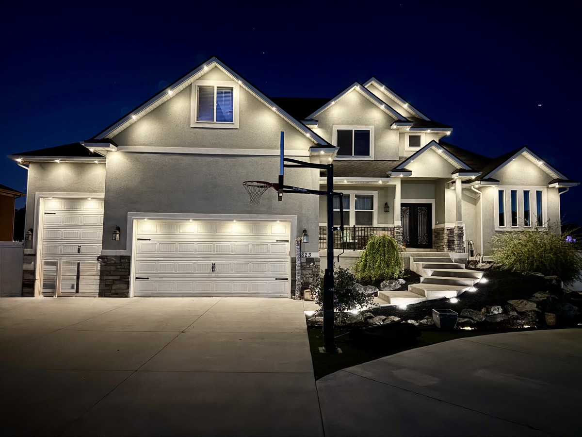 TruLight RGBW permanent lighting producing true warm white on a stucco home at dusk in Salt Lake City